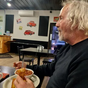 a man sitting at a table with a plate of food