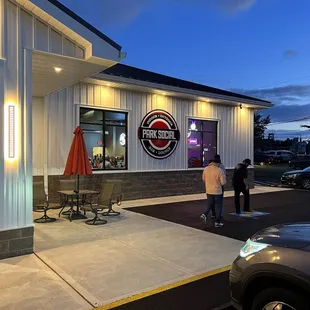 two people standing outside a restaurant
