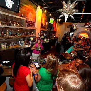 a crowd of people sitting at a bar