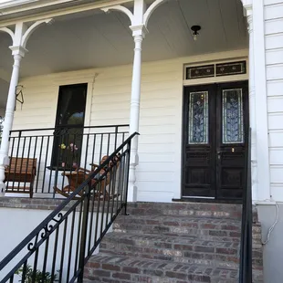 Front door with beautiful stained glass. Wonderful porch area with plenty of seating to relax and take in the view.