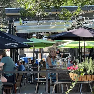 people sitting at tables with umbrellas