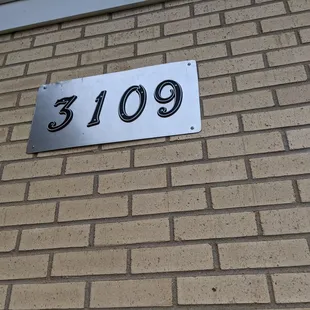 a number plate on a brick wall