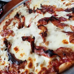 a pizza with bacon and cheese