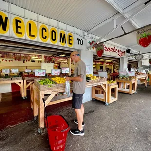 a man standing in front of a fruit stand