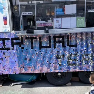 a little boy standing in front of a food truck