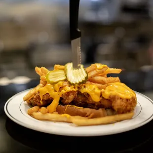 a fried chicken sandwich with cheese and pickles