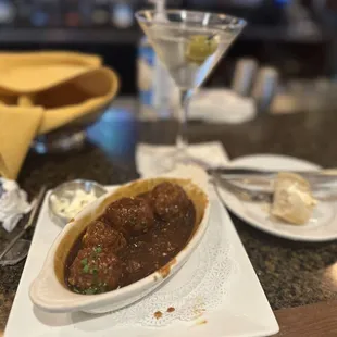 a plate of meatballs and a martini