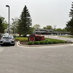 a woman walking past a tractor in a parking lot