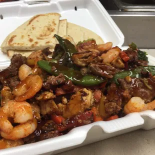 Combo stir fry .... Rice topped with chicken,steak,shrimp,vegetables,glaze sauce side of pita bread