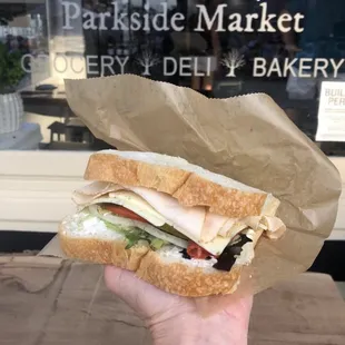 a hand holding a sandwich