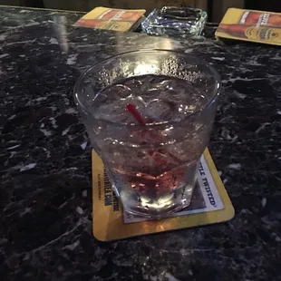 a glass of water with a red straw