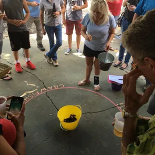 a group of people gathered around a yellow bucket
