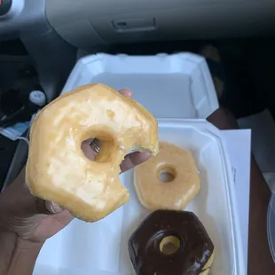a hand holding a half eaten doughnut