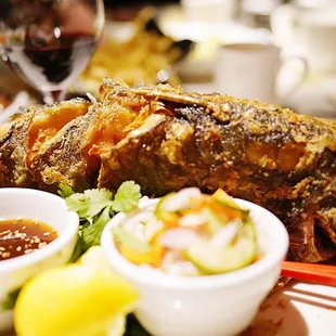 a plate of fish with dipping sauces