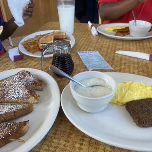 a breakfast of french toast, eggs, toast, and yogurt