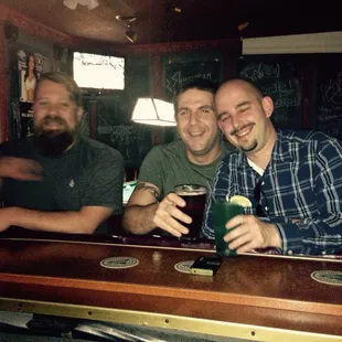three men sitting at a bar