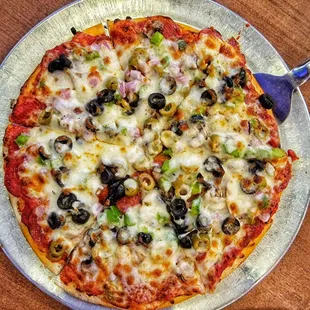 a pizza with olives, ham, and cheese