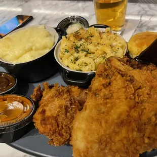 a plate of fried chicken, mashed potatoes, and sides