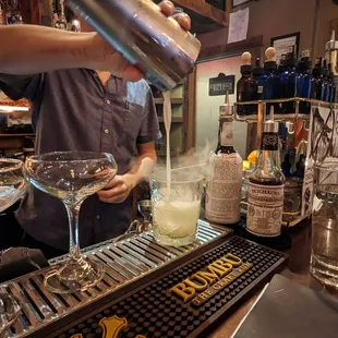 a bartender pouring a drink at a bar