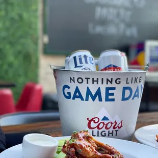 a plate of chicken wings and a bucket of beer