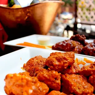 a plate of chicken wings and carrots