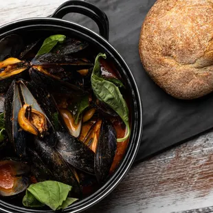 a pot of mussels and a loaf of bread