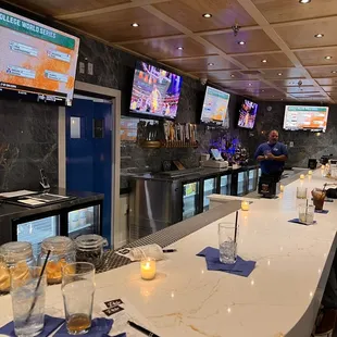 people sitting at the bar watching tvs