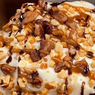a close up of a doughnut with nuts and cream