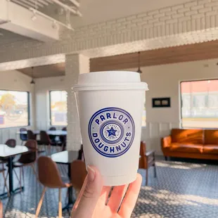 a hand holding a coffee cup