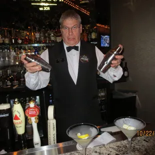 a bartender holding two bottles of liquor