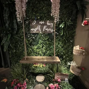 a wooden swing with flowers and greenery