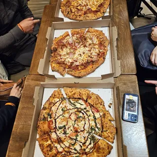 three pizzas on a table