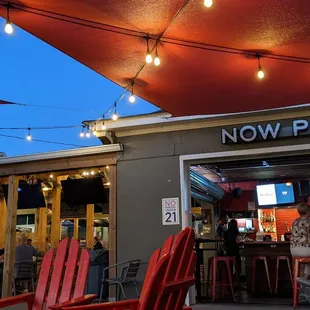 a restaurant with red chairs under a red awning