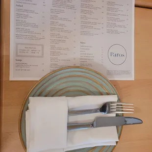 a place setting with a menu and fork and knife