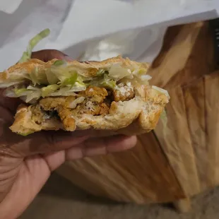 a hand holding a sandwich