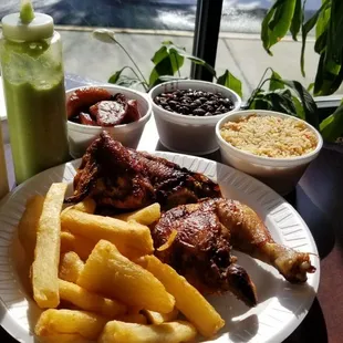 Half a juicy flavorful chicken with a side of fried yuca, fried rice, black beans, and plantains... and look at those bottles