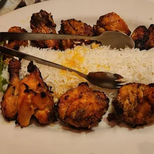 Joojeh kabob (Cornish game hen pieces) bone in, with rice.