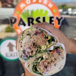 a hand holding a sandwich