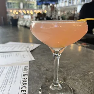 a pink cocktail in a coupe glass