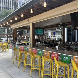 a bar with yellow chairs