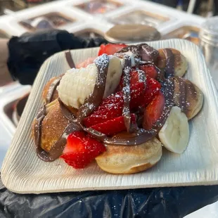 a waffle with bananas, strawberries, and chocolate
