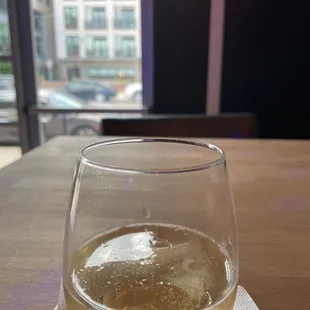a glass of white wine on a table