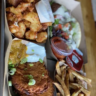 a tray of food including a burger, fries, and coleslaw