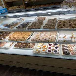 A huge display of doughnuts plus a few still on the side shelves