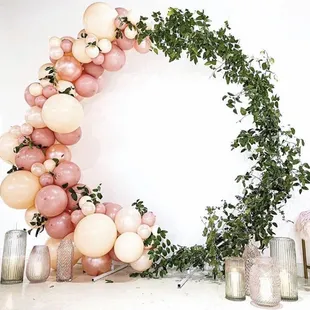 Balloon garland on a round stand with greenery