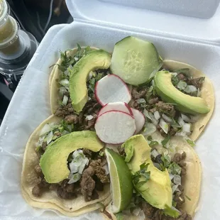 4 steak tacos with cilantro, onions, and avocado