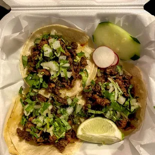 Steak tacos with onion and cilantro.