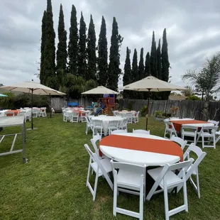 California Market Umbrellas, white resin padded chairs, 60" round tables, white round linen