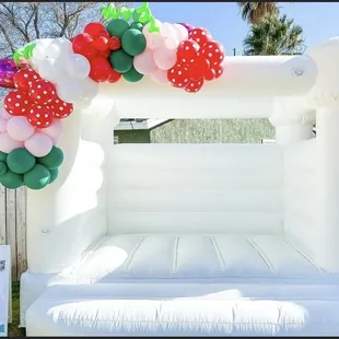 Bounce House with a Strawberry  Theme Ballon Garland.