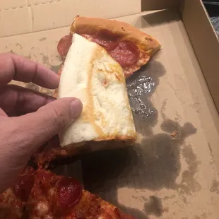 a person taking a slice of pizza